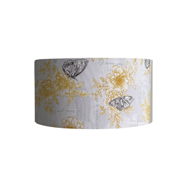 Barrel lampshade with summer romance fabric with yellow flowers, black etched butterflies on a white background, handcrafted by shades at grays.
