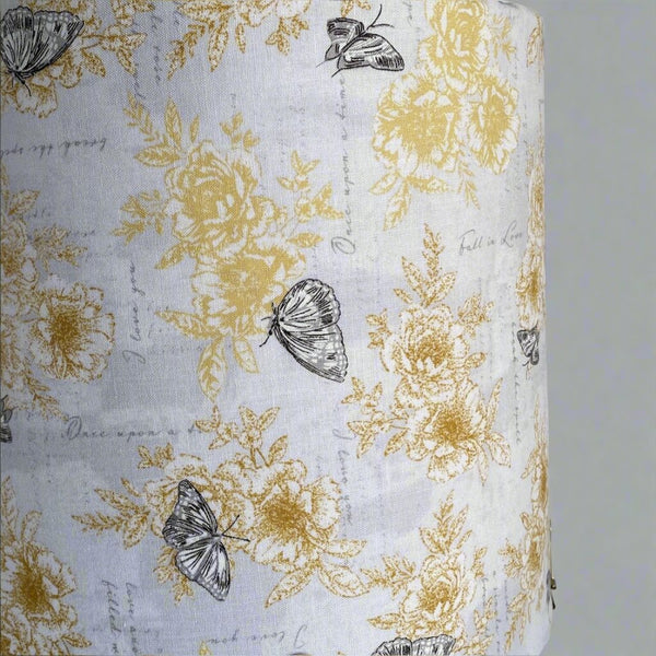 Lampshade with summer romance fabric with yellow flowers, black etched butterflies on a white background, close up, handcrafted by shades at grays.