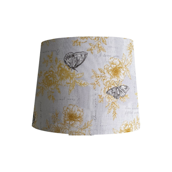 Tapered lampshade with summer romance fabric with yellow flowers, black etched butterflies on a white background, handcrafted by shades at grays.