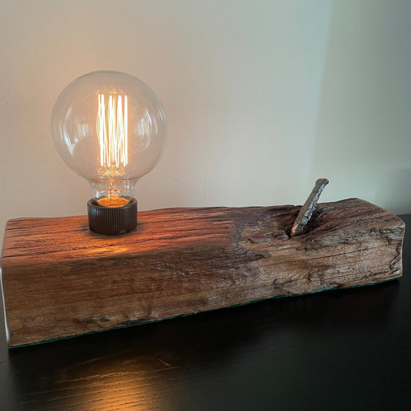 Upcycled wood table lamp from origianl wharf timber, vintage nail and replica edison bulb, lit, handcrafted
 by shades at grays.