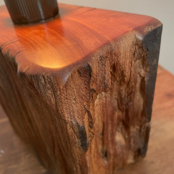 Wood table lamp made from upcycled wharf timber and replica edison bulb, lit, close up of side view, handcrafted by shades at grays.