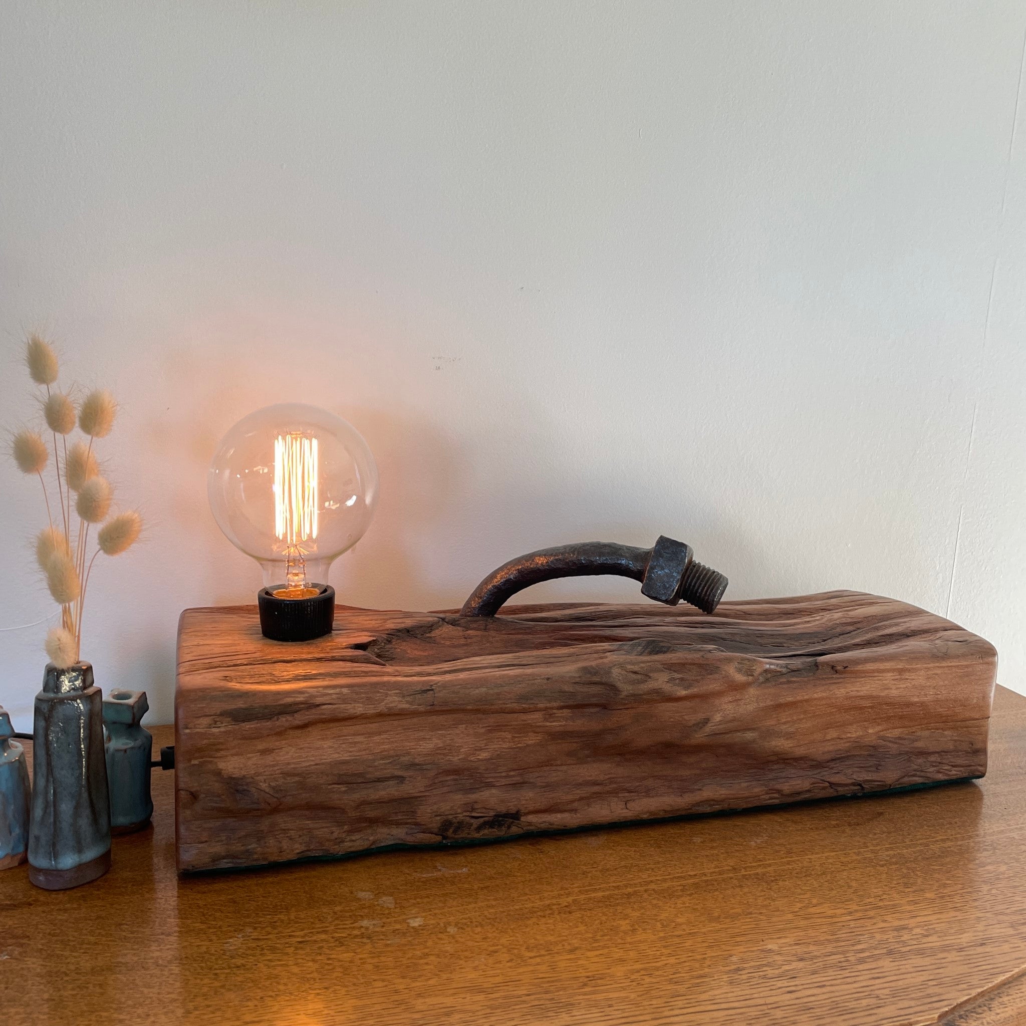 Wood lamp from 100 year old reclaimed wharf timber, with large original bolt, front view, lit, crafted by shades at grays