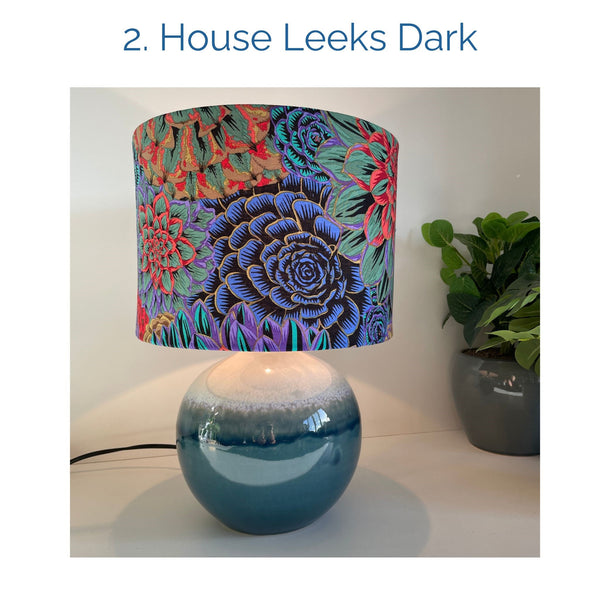 House Leeks Dark fabric lampshade on blue ceramic base, lit, by shades at grays.