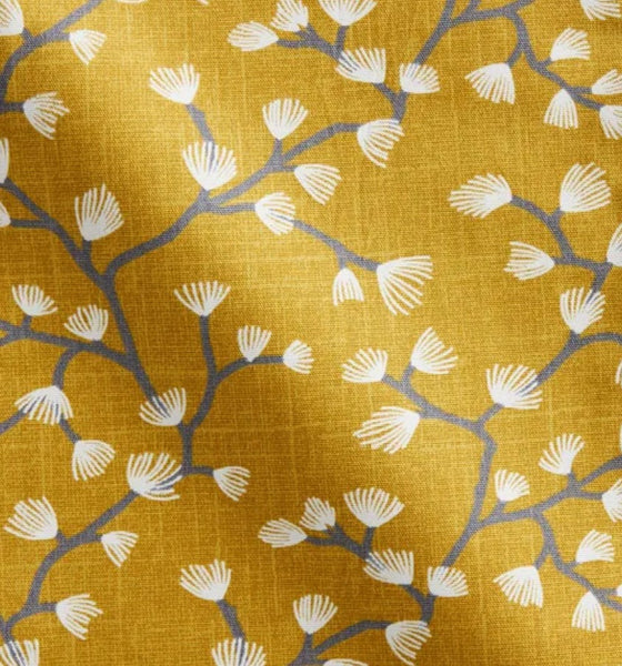 Close up of Spring Buds Sunflower fabric: cream fan-shaped buds on soft grey branching stems against a rich golden yellow background.