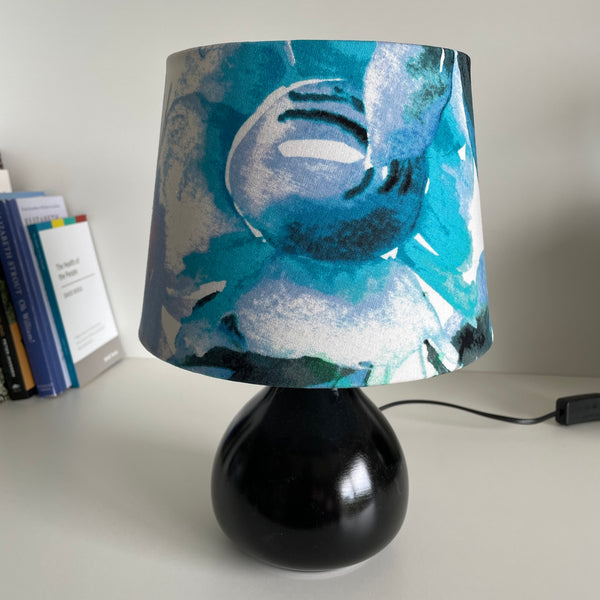 21 cm tapered lampshade, handcrafted in watercolour fabric on black base, unlit.