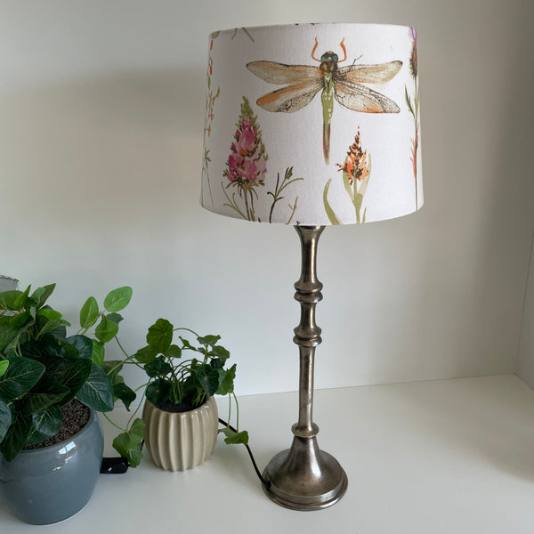 Antique silver candlestick lamp base styled with a tapered dragonfly and floral lampshade, sold separately