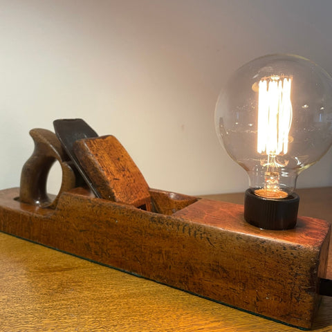 Wood table lamp upcycled from vintage carpenters plane with replica edison bulb, side view of cutting blade and bulb, crafted by shades at grays.