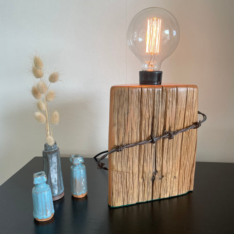 Authentic tōtara fence post upcycled by shades at grays to unique lamp with edison bulb, lit.