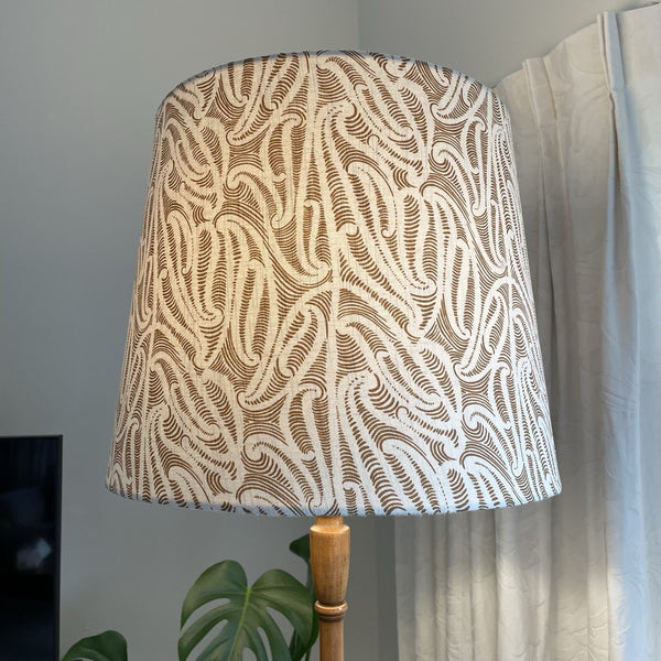 Bespoke tapered lampshade with ihi fabric Pākākā, lit, crafted by shades at grays, nz.