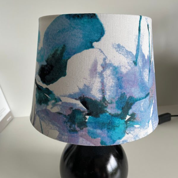 Blues and purples on a clean white background of this watercolour fabric lampshade by shades at grays, unlit.