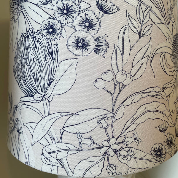Botanical print lampshade close up of print on pale pink textured background.
