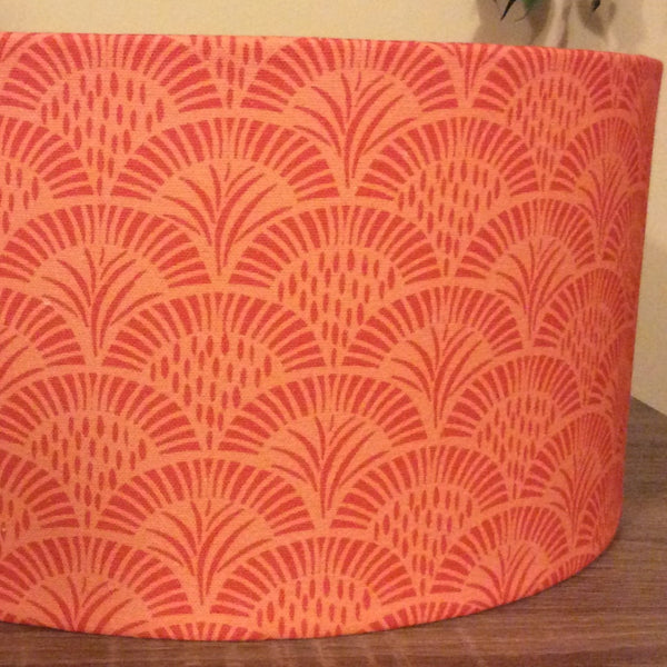 Close up of medium barrel lamp shade with orange cresecent print.