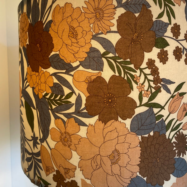 Close up of Large drum lamp shade made in nz by shades at grays, mid century brown floral print, lit.
