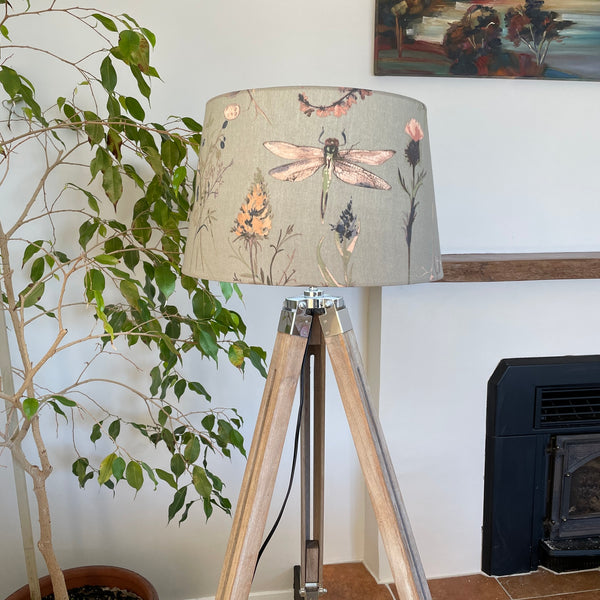 Dragonfly grey fabric on large tapered lampshade handcrafted by shades at grays, unlit on tripod floor stand.