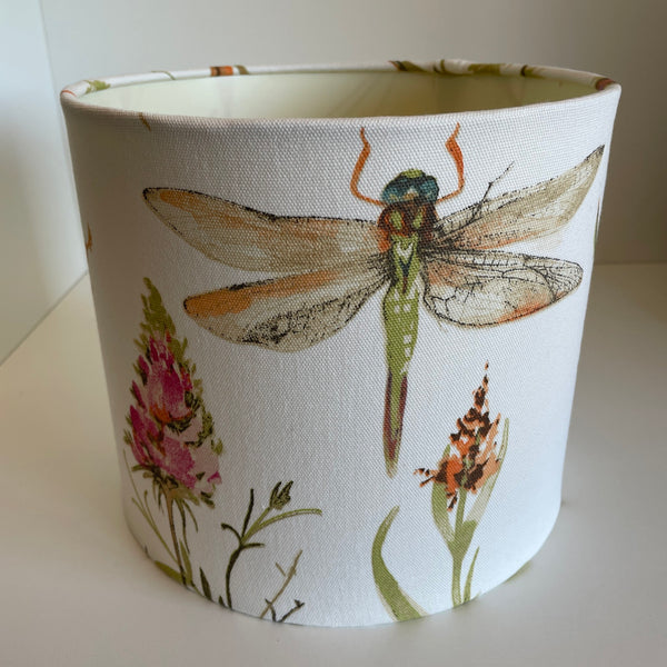 Dragonfly centred on cream dragonfly handmade lampshade with pink flower on a warm cream background, unlit.