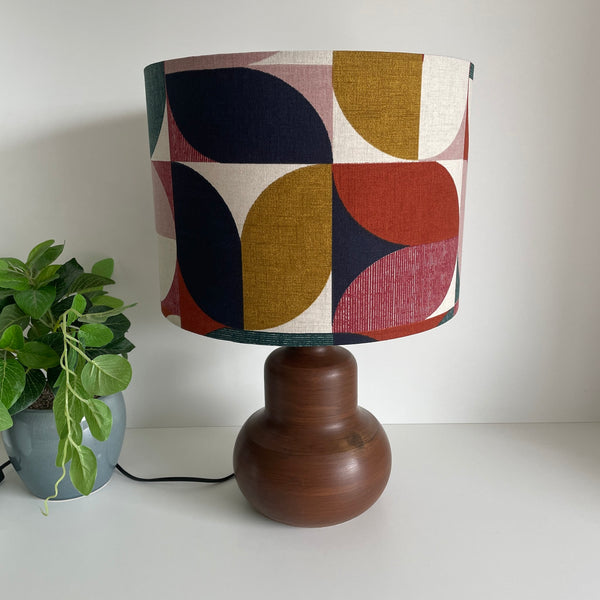 Drum lampshade with Bold and Beautiful fabric on java wood base, unlit by shades at grays.