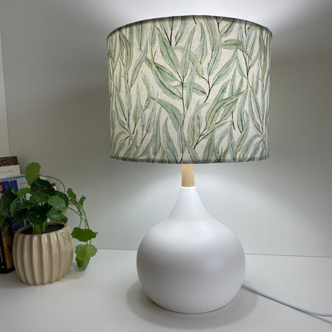 Drum lampshade with eucalyptus fabric on white base, lit, handcrafted by shades at grays, nz