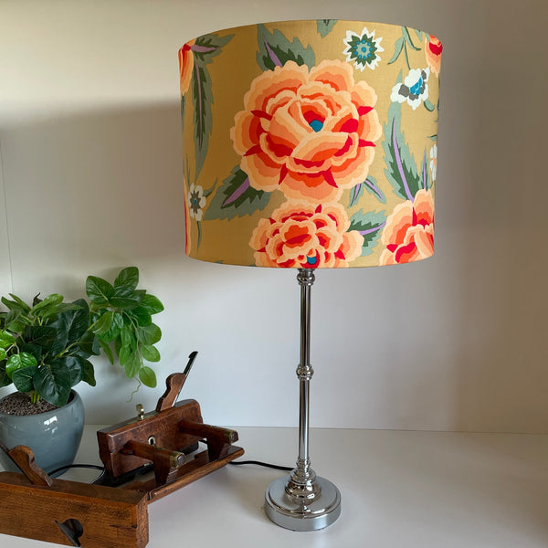 Drum style lampshade with Kaffe Fassett fabric, unlit on brushed metal lamp base.