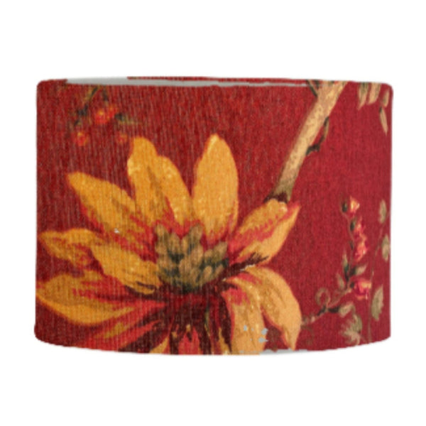 Drum style lamp shade with golden harvest on red fabric.