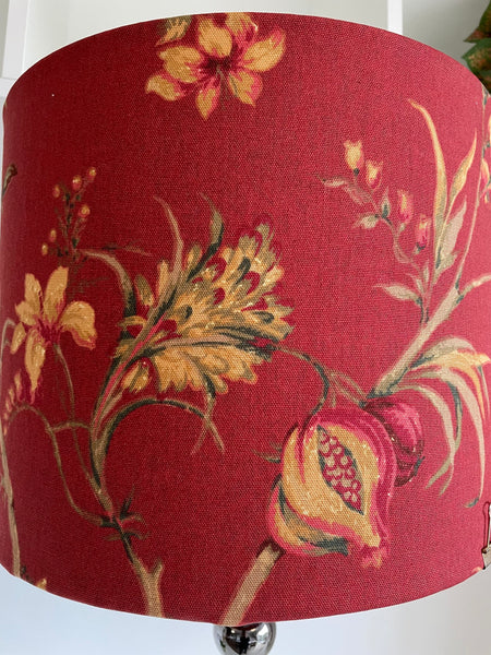 Drum style lamp shade with golden fruits and flowers on warm red background, handcrafted light shade, made in New Zealand.