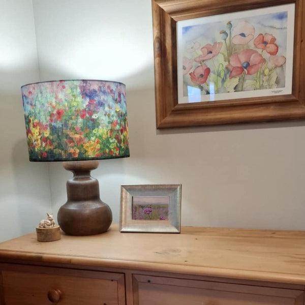 Wooden dresser with a java wood lamp and garden envy lampshade and framed picture in a room setting