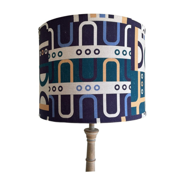 Geometric harmony blue fabric with navy, blue, teal, yellow and white shapes on handcrafted light shade.