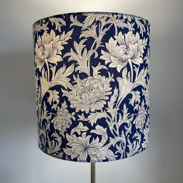 Handcrafted William Morris  blue chrysantemum fabric lampshade, 25 cm x 25cm cylinder, lit, by shades at grays.