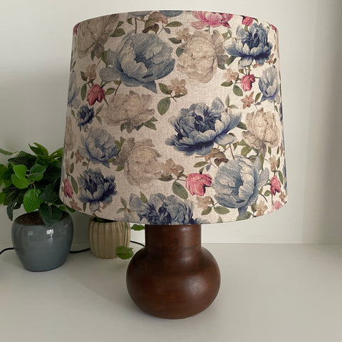 Handcrafted large tapered lampshade with blossoms on grey fabric, unlit, on brown base by shades at grays.