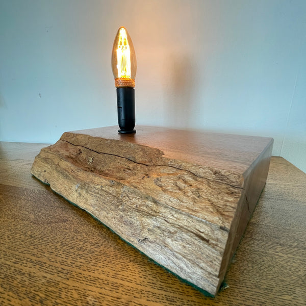 Handcrafted heritage lamp by shades at grays using a reclaimed jarrah beam with additional candle bulb, lit, side and front view.