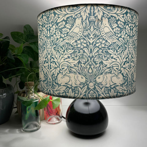 Handcrafted lampshade, medium drum with William Morris Brer Rabbitt fabric on small black lamp base, by shades at grays nz.