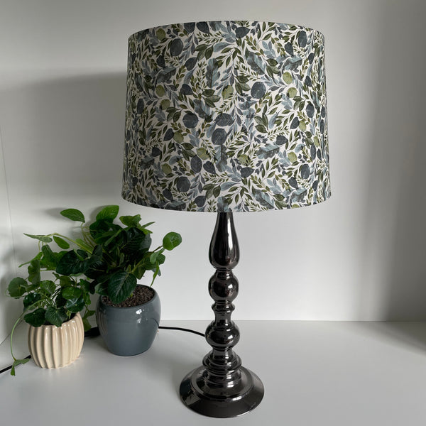 Handcrafted lampshade with Serenity Leaves fabric, tapered 38 shade size, on grey metal stand,by shades at grays, unlit.