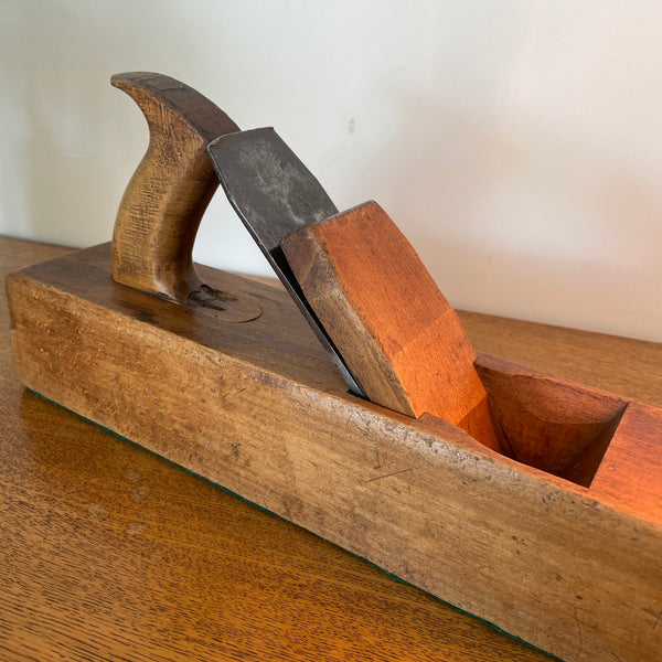 Heritage lamp crafted by shades at grays from original carpenters' half jack plane with replica edison bulb, lit, close up of mid section.