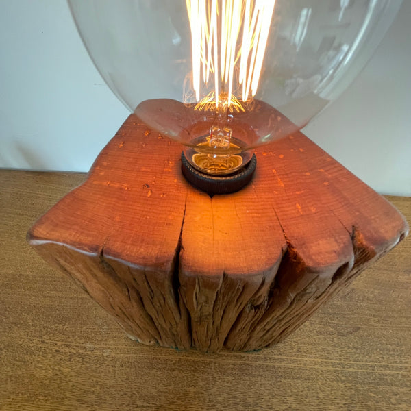 Heritage lamp upcycled by shades at grays, of Totara fencepost, smooth top grain and lit replica edison bulb.
