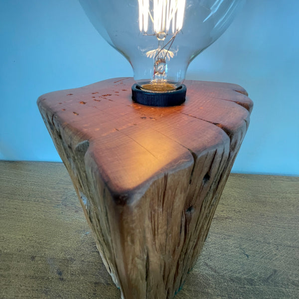 Heritage lamp upcycled by shades at grays, of Totara fencepost with wide lined front with several staple holes, side view.