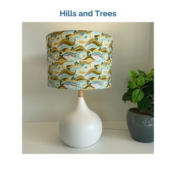 Hills and trees fabric on white touch lamp, lit, crafted by shades at grays.