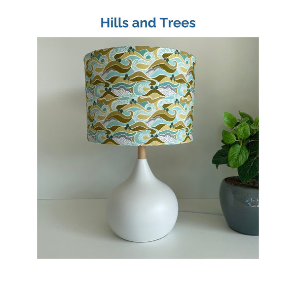 Hills and trees fabric on white touch lamp, unlit, crafted by shades at grays.