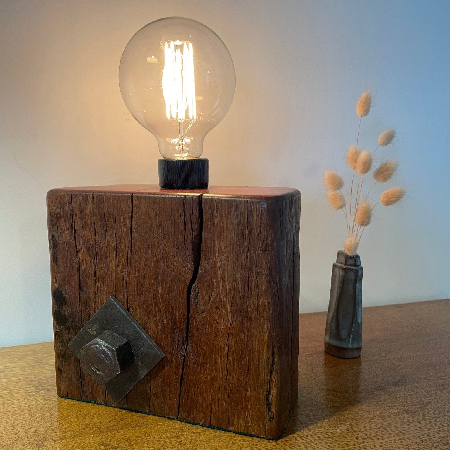 Upcycled jarrah wharf wood lamp, cleaned and polished with natural beeswax, front view with authentic bolt and replica edision bulb, lit, handcrafted by shades at grays.