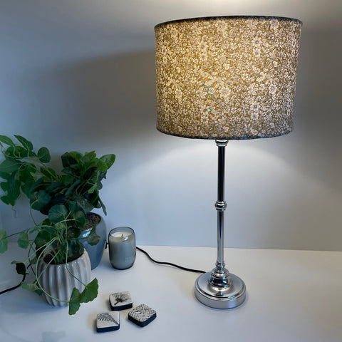 Medium drum lamp shade with manuka sage fabric on silver stand, lit. By shades at grays nz.