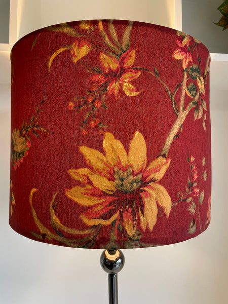 Large golden flower on branch showcases handmade fabric lampshade, drum style.