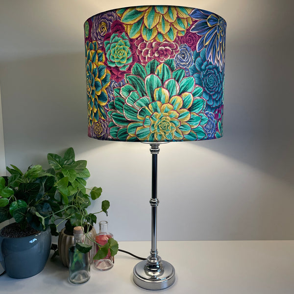 Large drum bespoke lamp shade made in nz by shades at grays using Kaffe Fassett House Leeks fabric grey, lit on silver base.