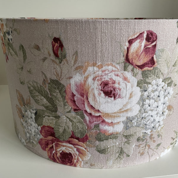 Large 45 cm barrel lampshade with vintage flower fabric, unlit, close up by shades at grays.
