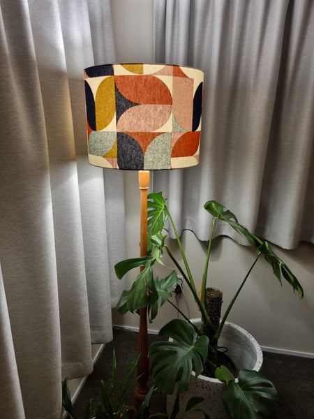 Large drum lampshade in bold and beautiful fabric based on geometric pattern, on wooden floor stand, handcrafted by shades at grays.
