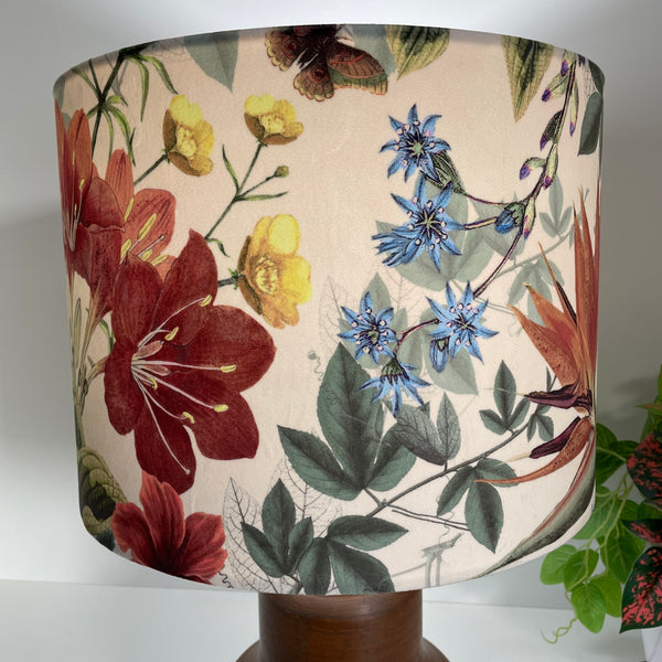 Large drum lampshade, lit, handcrafted by shades at grays with velvet fabric showing close up of flowers in variety of colours.