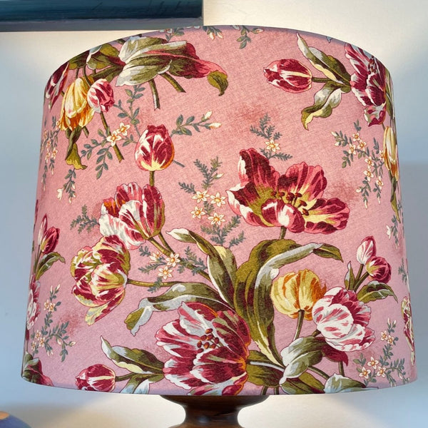 Large tapered handcrafted lampshade with tulip bouquet fabric with fresh pink background and red and yellow tulips, by shades at grays.