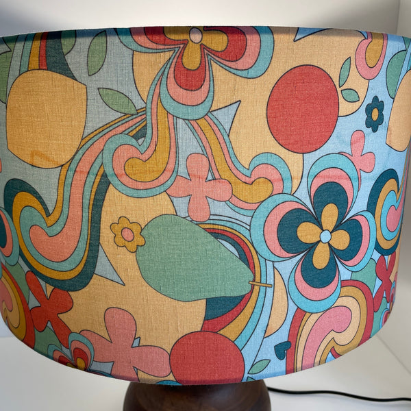 Large barrel with 60s swirl fabric, lit, close up of watermark on fabric, by shades at grays.