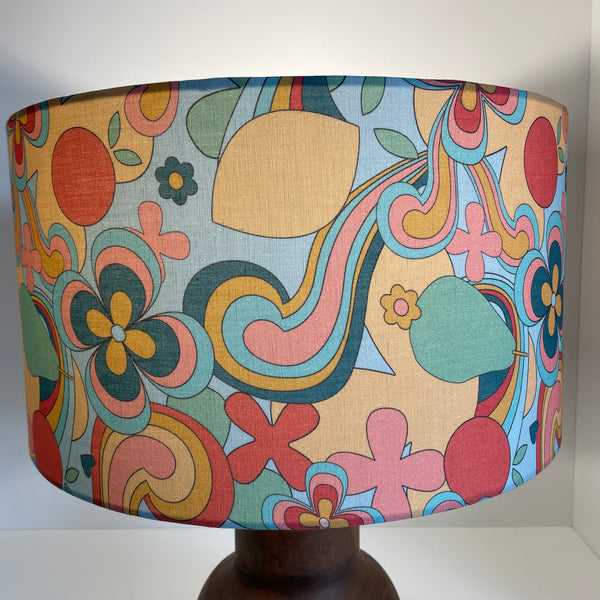 Large barrel with 60s swirl fabric, lit, by shades at grays.