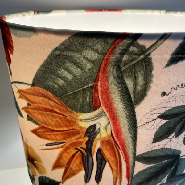 Large drum lampshade with velvet bouquet fabric, lit, crease damage close up of one portion.