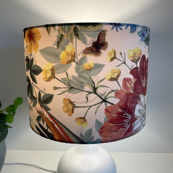 Large drum lampshade with velvet bouquet fabric, lit, long view.
