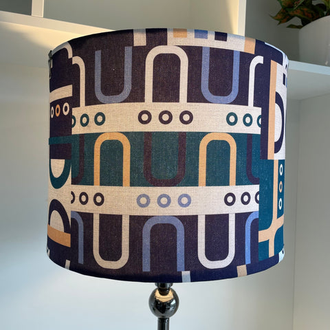 Large drum style lampshade with geometric harmony blue fabric, lit, handcrafted by shades at grays, nz.