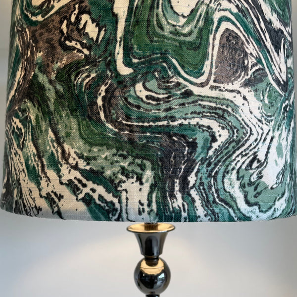 Large drum style lampshade with greywacke fabric, moss green, grey and white swirls, close up.